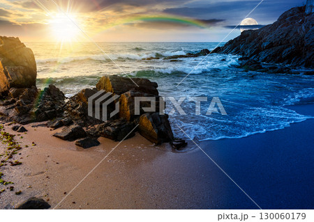 landscape by the sea in summer. day and night time change concept. beautiful beach with rocks washed by calm waves with sun and moon at twilight. view to horizon under blue sky with clouds landscape by the sea in summer. day and night time change concept. beautiful beach with rocks washed by calm waves with sun and moon at twilight. view to horizon under blue sky with clouds 130060179