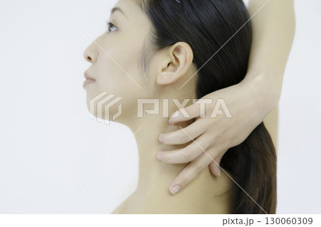 白背景のうなじを触る若い女性の顔のアップ 130060309