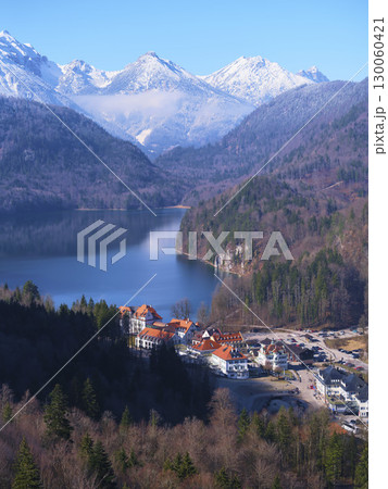 Scenic winter view of a lakeside village surrounded by snow-capped mountains in Bavaria's breathtaking landscape 130060421