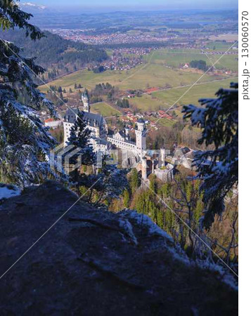 Spectacular view of a castle surrounded by forests and mountains in winter at midday in Bavaria 130060570