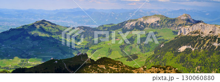 Majestic mountain landscape with rolling green hills under a bright sky in the Alps Majestic mountain landscape with rolling green hills under a bright sky in the Alps 130060880