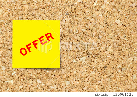 Yellow note paper with word offer on cork board background with copy space 130061526