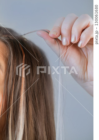 Salon hair extension procedure with each strand carefully prepared by professional hairstylist for perfect results Salon hair extension procedure with each strand carefully prepared by professional hairstylist for perfect results 130061680