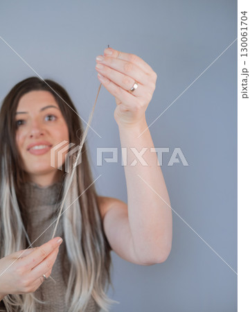Hair extension procedure using thin capsules in professional beauty salon by skilled hairstylist Hair extension procedure using thin capsules in professional beauty salon by skilled hairstylist 130061704