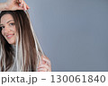 Woman hairstyle after capsule hair extensions showing healthy shiny strands in modern beauty salon 130061840