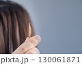 Stylist showing the result of a professional hair extension procedure in a modern beauty salon 130061871