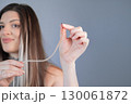 Beauty and care young woman with thick strands after professional hair extension procedure in modern beauty salon 130061872