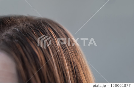 Professional hair extension process with thin capsules hair care treatment in a beauty salon by skilled hairstylist 130061877