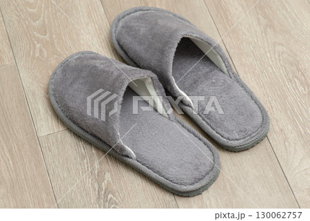 Top down shot of gray slippers on the floor. Wearing slippers at home concept Top down shot of gray slippers on the floor. Wearing slippers at home concept 130062757