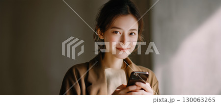 スマートフォンを操作する／使っている／さわっている女性 130063265