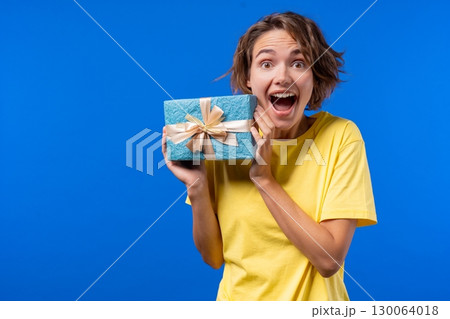 Happy Woman Gift Box On Blue Background. Young amazed Girl Smiling, got present Happy Woman Gift Box On Blue Background. Young amazed Girl Smiling, got present 130064018