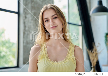 Headshot portrait young beautiful blonde female 18-20 years old in home interior 130064110