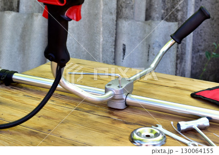 View of the handles of a petrol trimmer. View of the handles of a petrol trimmer. 130064155