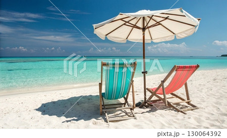 Scenic tropical beach with two colorful striped deck chairs under a large parasol Scenic tropical beach with two colorful striped deck chairs under a large parasol 130064392