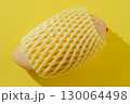 Mango Wrapped in Foam Net on a Yellow Background 130064498