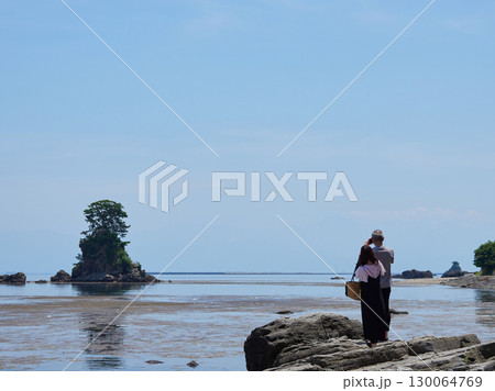 夏の富山湾の観光名所雨晴海岸の男岩の風景と観光客の姿 夏の富山湾の観光名所雨晴海岸の男岩の風景と観光客の姿 130064769