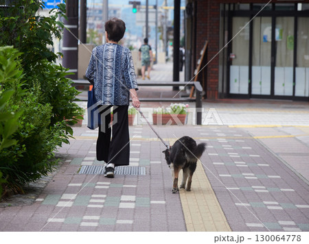 夏の高山の街で犬を連れて散歩するシニア女性の姿 夏の高山の街で犬を連れて散歩するシニア女性の姿 130064778