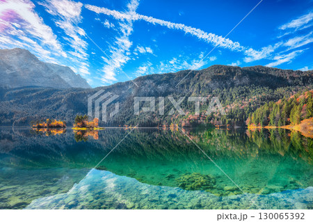 Stunning autumn landscape of Eibsee Lake in front of Zugspitze summit under sunlight. 130065392