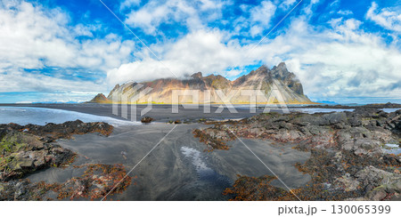 Amazing sunny day and dramatic black sand beach on Stokksnes cape in Iceland Amazing sunny day and dramatic black sand beach on Stokksnes cape in Iceland 130065399