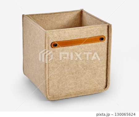 Beige felt storage box with leather handle on white background Beige felt storage box with leather handle on white background 130065624