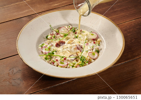 Chef pouring okroshka, traditional russian cold soup, into bowl 130065651