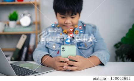 Asian boy using smartphone with social media icons and online communication concept Asian boy using smartphone with social media icons and online communication concept 130065695