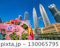 Vibrant traditional Wau Bulan moon kite with iconic Petronas Twin Towers and modern cityscape in the background, Kuala Lumpur, Malaysia. Clear blue sky, sunny day, Malaysian cultural heritage, KLCC 130065795
