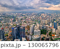 Panoramic aerial view, Kuala Lumpur, Malaysia, urban skyline, high-rise buildings, suburban areas, mountains in background, dense city architecture, transportation networks, dramatic sky at daytime 130065796