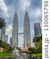 Nov 20, 2019 - Kuala Lumpur, Malaysia: Petronas Twin Towers with skybridge in urban skyline during daytime under dramatic cloudy sky. Scenic cityscape with lush park, pond, bridge and modern Whale and 130065798