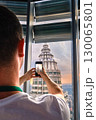 Nov 20, 2019 - Kuala Lumpur, Malaysia: Unrecognizable male adult tourist taking photo of Petronas tower with smartphone through window at colorful sunset.Observation deck visit, tourist attraction 130065801