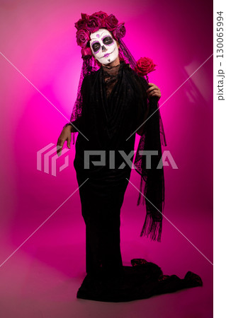 Girl With Sugar Skull Makeup and Roses Celebrates Day of the Dead 130065994