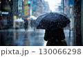 大雨のなか傘をさして歩いている女性 130066298