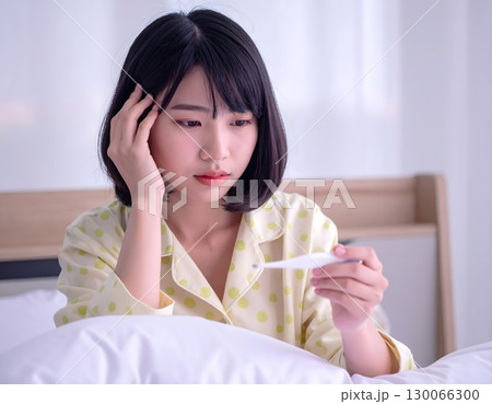 風邪を引いた女性のポートレート、部屋の中で 130066300
