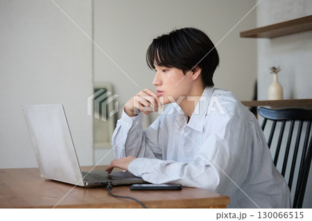 自宅で仕事をしているアジアの若い男性 130066515
