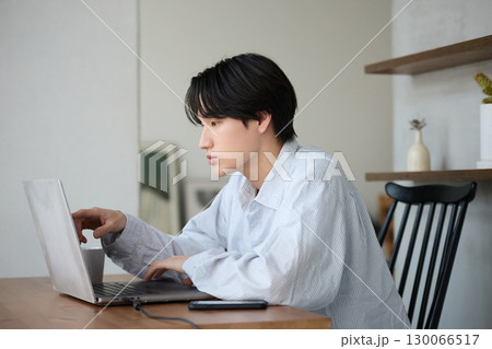 自宅で仕事をしているアジアの若い男性 130066517