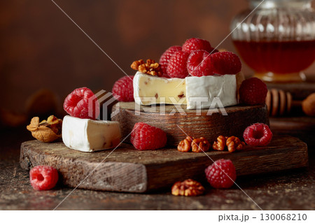 Camembert cheese with fresh raspberries and walnuts. 130068210