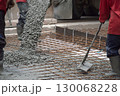 Workers are pouring concrete and cement at the construction site. 130068228