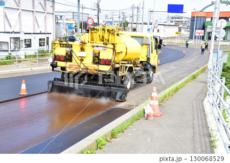 道路の舗装工事でアスファルト乳剤の散布作業 道路の舗装工事でアスファルト乳剤の散布作業 130068529