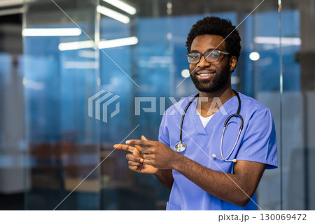 Healthcare professional in blue scrubs standing in a bright and modern office. Smiling and confident, demonstrating approachability and professionalism Healthcare professional in blue scrubs standing in a bright and modern office. Smiling and confident, demonstrating approachability and professionalism 130069472