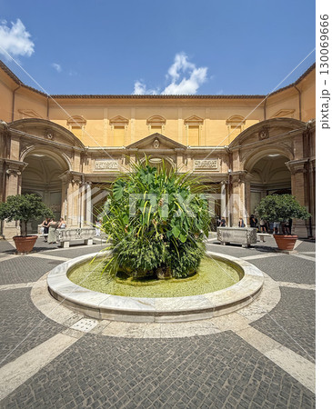 Vatican City, ROME, ITALY - AUGUST 02, 2025 The Octagonal Court (Cortile delle Statue) with a central fountain with lush green plants stands in a courtyard, framed by classic Italian architecture 130069666