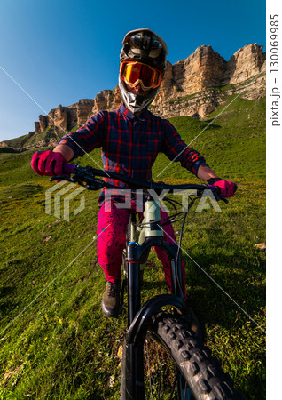 Sports. A cyclist stands alone in a field. A person riding a bicycle in a downhill style. 130069985
