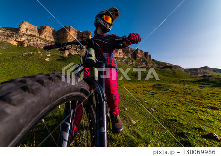 Vertical photo of young athlete view from above wide angle. Professional rider on mountain bike Vertical photo of young athlete view from above wide angle. Professional rider on mountain bike 130069986