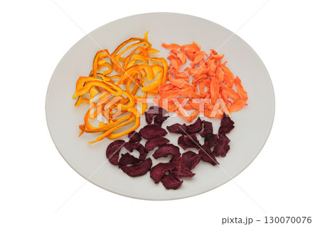 Adventure food. Nutritious snacks. Dried beetroot, sweet pepper and carrot on a ceramic plate isolated on a white background. Various dry of vegetables. Adventure food. Nutritious snacks. Dried beetroot, sweet pepper and carrot on a ceramic plate isolated on a white background. Various dry of vegetables. 130070076