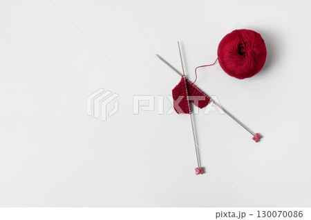Vinous knitted wool on gray background with knitting needles for knitting warm clothes and hobbies needlework 130070086