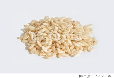 Heap of raw brown rice grains on white background for healthy natural cooking Heap of raw brown rice grains on white background for healthy natural cooking 130070250