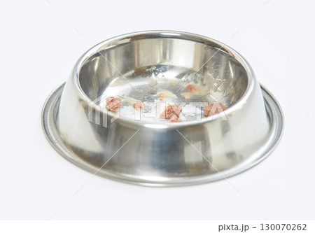 close up of a stainless steel pet bowl with remaining wet food pieces on a white close up of a stainless steel pet bowl with remaining wet food pieces on a white 130070262