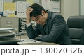 オフィスで仕事の悩みで深刻な表情で頭を抱え考え込むビジネスマン 130070326