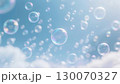 白い雲の浮かぶ青空と、太陽の光を浴びて虹色に輝く無数のシャボン玉 130070327