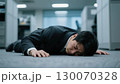 仕事に疲れてオフィスに倒れ込むビジネスマン(疲労困憊、絶望、敗北感、急病) 130070328