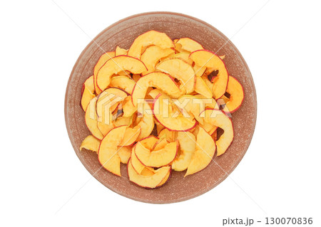 Dried apples in a plate isolated on a white background. Various dry slices of fruits. Homemade preparation of snack. Top view. 130070836